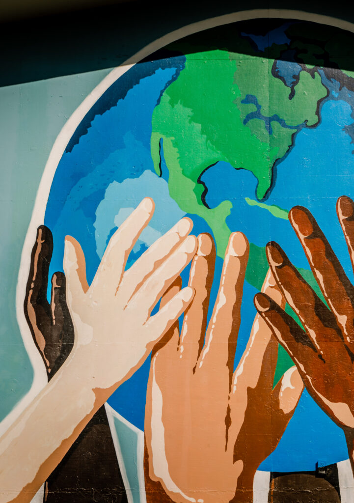 Painting of a hand on a globe model